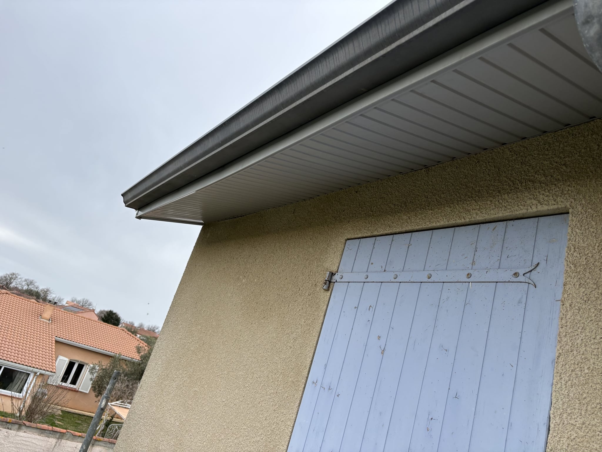 Gouttière en zinc avec sous-face en PVC gris anthracite fixée sous le toit.